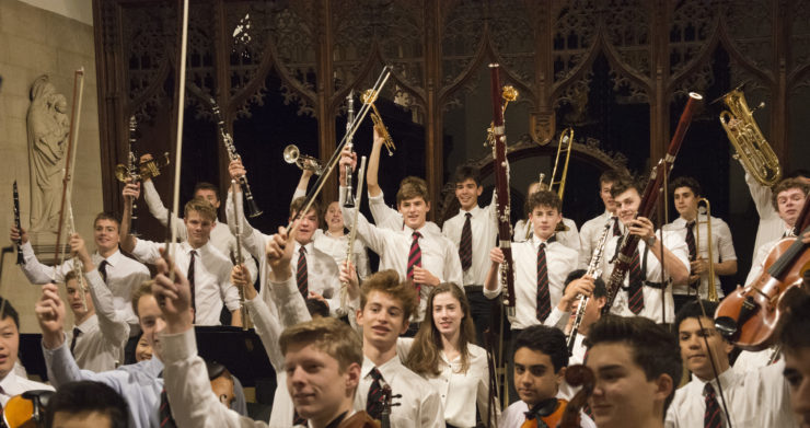 Magdalen College School pupils waving musical instruments in the chapel of St John the Evangelist Oxford