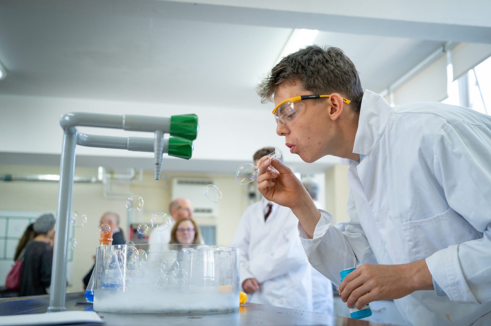 Chemistry Practical at Magdalen College School With A Pupil Blowing Bubbles Into A Large Container Which Is Creating Vapour