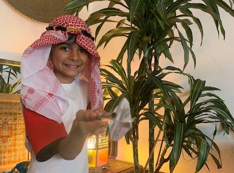 Magdalen College Junior School pupil in middle eastern costume holding a spear